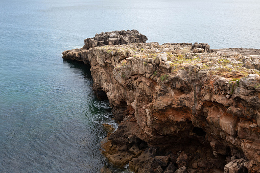 Seascape. View of the rocks against the calm waters of the Atlantic Ocean in Cascais, Portugal.