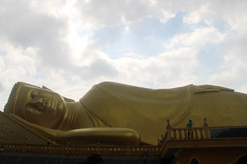 Giant bronze reclining Buddha statue in Khmer pagoda, Tra Vinh province