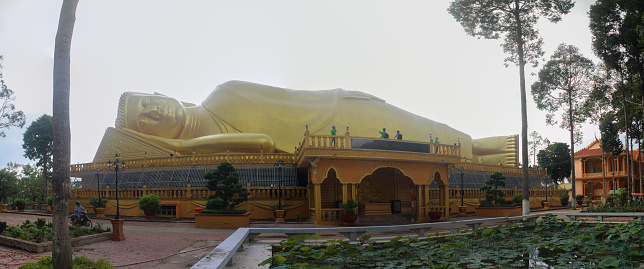 Giant bronze reclining Buddha statue in Khmer pagoda, Tra Vinh province