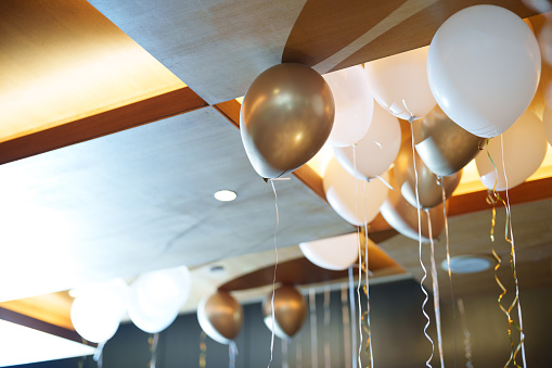Gold and white-colored balloons on the ceiling