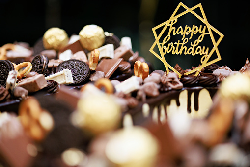 Birthday cake decorated with golden happy birthday sign close up