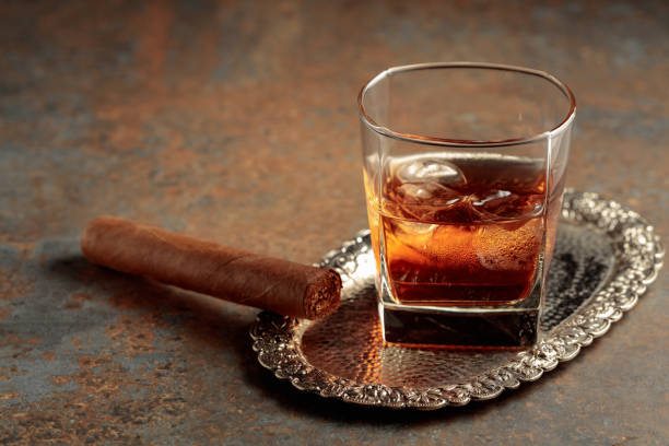 istock Whiskey with ice and cigar on a rusty background. 1720643682