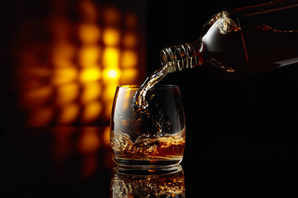 istock Pouring whiskey from a bottle into a glass. 1720644275