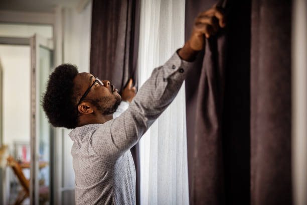 istock Businessman opens curtains in the morning 1720651360