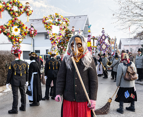 Gasteinertal, Austria – January 1, 2023: Witch in front of participants in the Perchtenlauf procession in the Austrian Gastein Valley