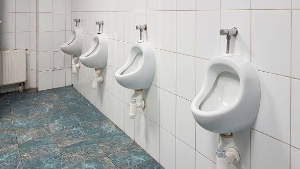 istock The bathroom interior is lined with white ceramic tiles. Oval ceramic urinal. Public place for coping needs. Ceramic household product. Saving running water in everyday life. Restroom Design Solution 1720667842