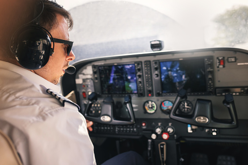 Handsome male pilot flying a private plane and wearing headset