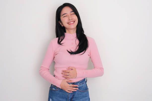 Asian young woman touching his stomach with relieved expression Asian young woman touching his stomach with relieved expression perasaan lega stock pictures, royalty-free photos & images