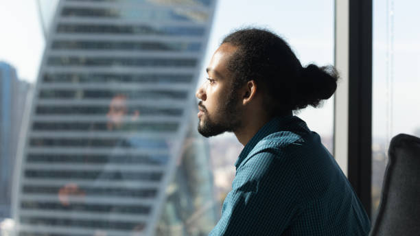 istock Side view dreamy African American businessman looking out window 1720679908