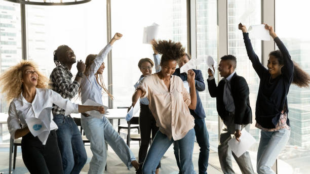 Overjoyed African American business people celebrating success, throwing papers