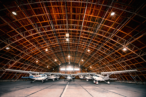 Lone drone U.A.V aircraft awaiting a military mission in a hanger. 3d model scene.