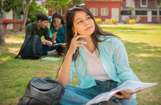 istock Young female university student thinking while studying and reading a book in a campus 1720690133