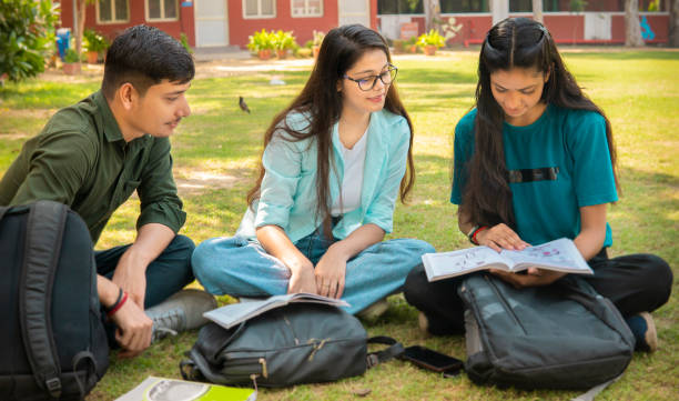 istock Students discussing together on a book in university campus ground. 1720690660