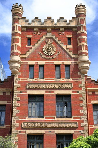 Former Salvation Army Training College built in AD 1901 on Victoria Parade in Gothic Tudor style of red brickwork facade, cement render quoining and tower with corner turrets. Melbourne-VIC-Australia.