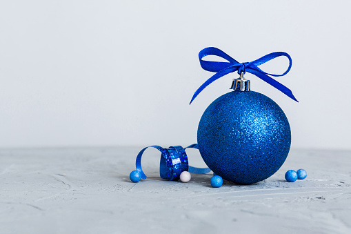 Christmas ball on colored background. decoration bauble with ribbon bow with copy space.