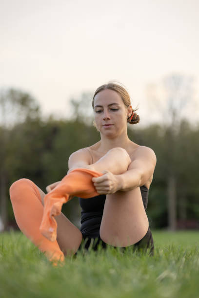 istock Young blonde athlete is wearing socks on the grass. 1720719328