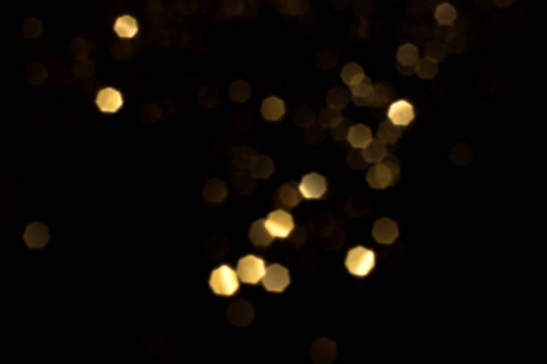 istock Golden blurred bokeh lights on black background 1720724988