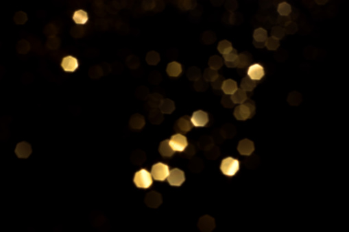 Abstract golden bokeh background with blur effects and sparks for a glamorous holiday concept.