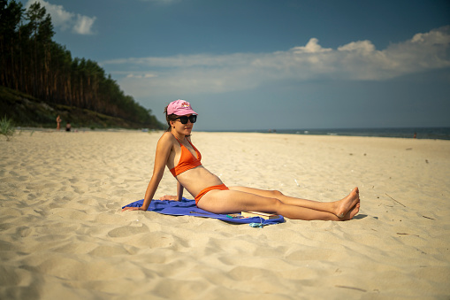 Young woman sunbathing on a sunny beach. Vacations at sea