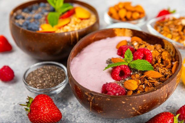 istock Useful breakfast. Granola bowl with yogurt and fresh berries on a textured kitchen table.Acai and spirulina bowl.Bowl of Greek yogurt with granola, almonds, blueberries, raspberries and strawberries. 1720763832