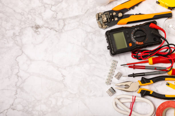 istock Electrician equipment on background with copy space.Top view.Electrician tool set.Multimeter, tester,screwdrivers,cutters,duct tape,lamps,tape measure and wires.Flet lay. 1720763884
