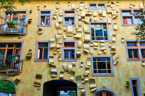Dresden, Germany - September, 23rd - 2023: Facade of a golden house with paper like documents fixed on the wall.