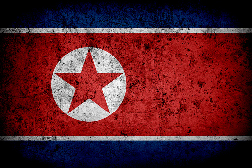 Flag of North Korea with faded grunge effect and vignette, perfect for backgrounds and design.