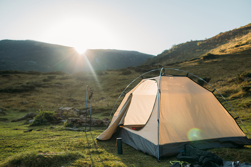 tent set in the mountains at sunset. The concept of active recreation