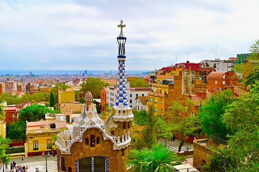 Barcelona, Spain: 10/05/2023- Parc Guell was commissioned by Eusebio Guell who wanted to creat a park for Barcelona aristocracy. The park contains organic looking columns made from stone, tile benches, buildings, and Gaudi dragons fountain.There is multi-corlored mosaic seats.