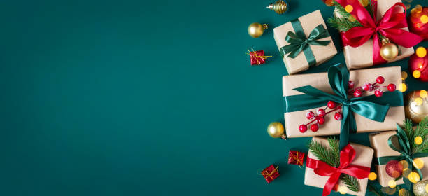 świąteczne zielone tło z pudełkami upominkowymi przewiązanymi jedwabnymi wstążkami i ozdobami świątecznymi. świąteczne tło. - gift blue christmas religious celebration zdjęcia i obrazy z banku zdjęć