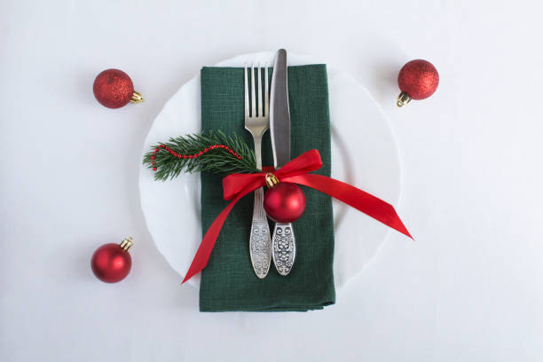 istock Christmas table setting with green napkin on the white tablecloth. Top view. Close-up. 1720834072