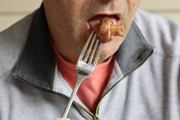 istock Close up of man eating fried mushroom in the fork. 1720855295