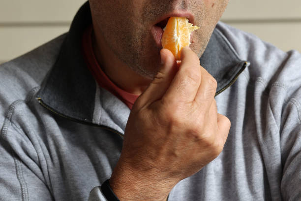 istock Person eating orange pieces 1720855324