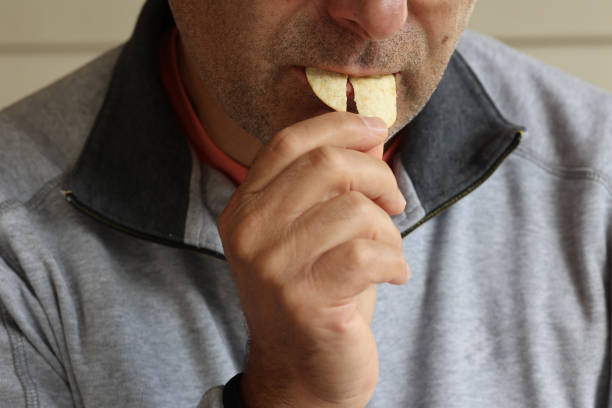 istock A man eating a chips. Unhealthy food. 1720855858