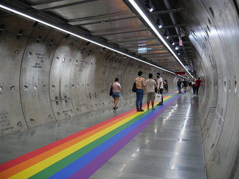 Bangkok, Thailand-June 3, 2021: Rainbow Pride on the floor in the pedestrian tunnel between a subway station and a shopping mall in Bangkok. People walking around and taking photos in the area.