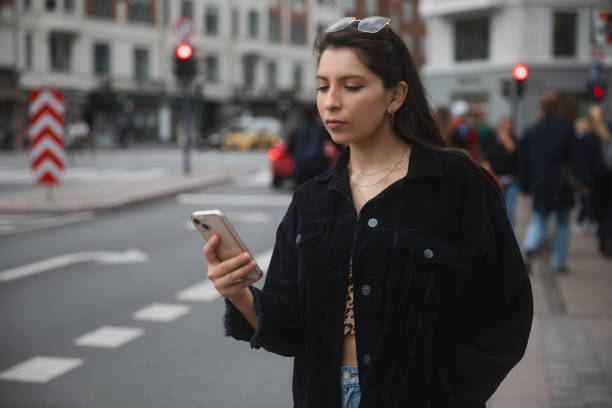 istock Young woman using smartphone on urban street 1720882799
