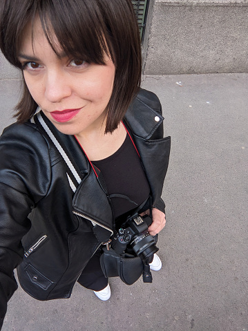 Selfie of a woman, a girl in black with a mirror camera