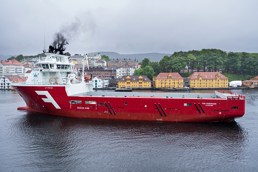 Bergen, Norway - June 6, 2017: platform-supply vessel ‘Far Serenade’ leaving the port of Bergen in the rain
