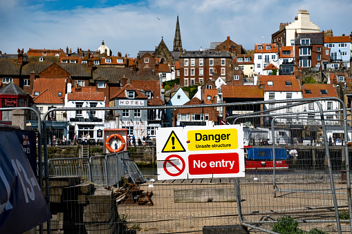 Whitby, Yorkshire, UK -  June 25 2023. Danger and Keep Out sign on a metal gate to restrict access