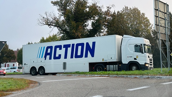 Sulzbach, Germany - October, 6th - 2023: Rural road in the morning. Huge truck with the text „Action“ visible.