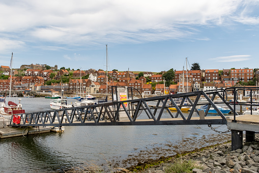 Whitby, Yorkshire, UK - June 25 2023. Bridge or gangplank down to the wooden jetty and pontoons in Whitby harbour on the North Yorkshire coast