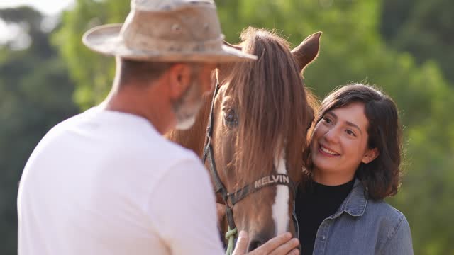 Father and daughter taking care of horse on a ranch