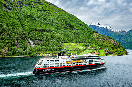 Geirangerfjord, Norway - June 7, 2017: Hurtigruten coastal vessel ‘Trollfjord’. Hurtigruten is a daily passenger and freight shipping service along Norway's coast between Bergen and Kirkenes.