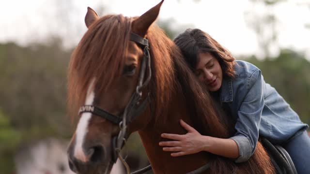 Young woman embracing her horse on a rural scene
