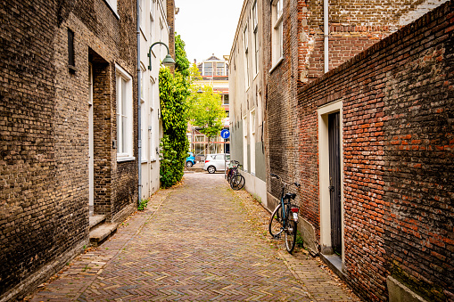 Side alley with cobblestones and bicycles parked by the side, Delft, the Netherlands