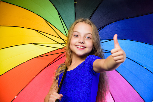 Happy childhood. School time. Autumn fashion. Child. Happy little girl with umbrella. Feeling protected at this autumn day. Small girl with umbrella in rainy weather.