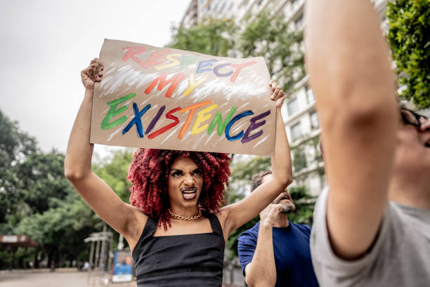 Transgender person holding a sign during a protest in the city street