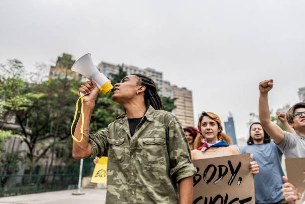 istock Young man talking in a megaphone during a protest in the street 1721100973