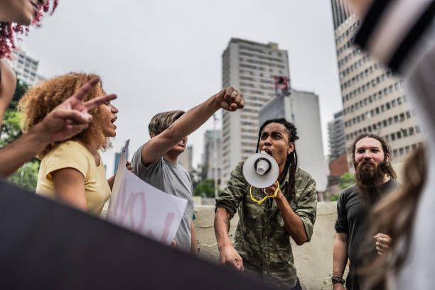 Young man talking in a megaphone during a protest in the street