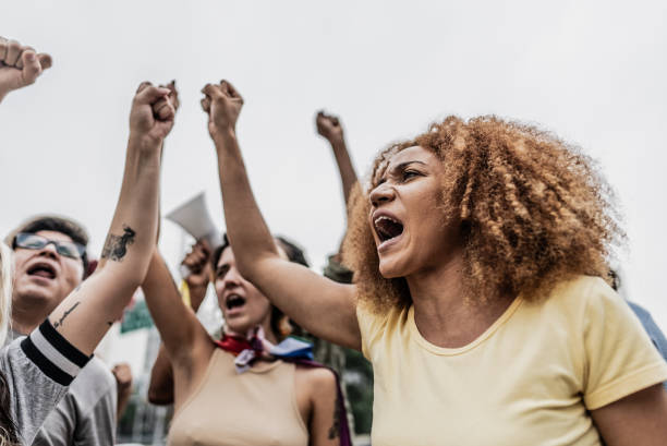 istock Protestors with fist up marching outdoors 1721103206